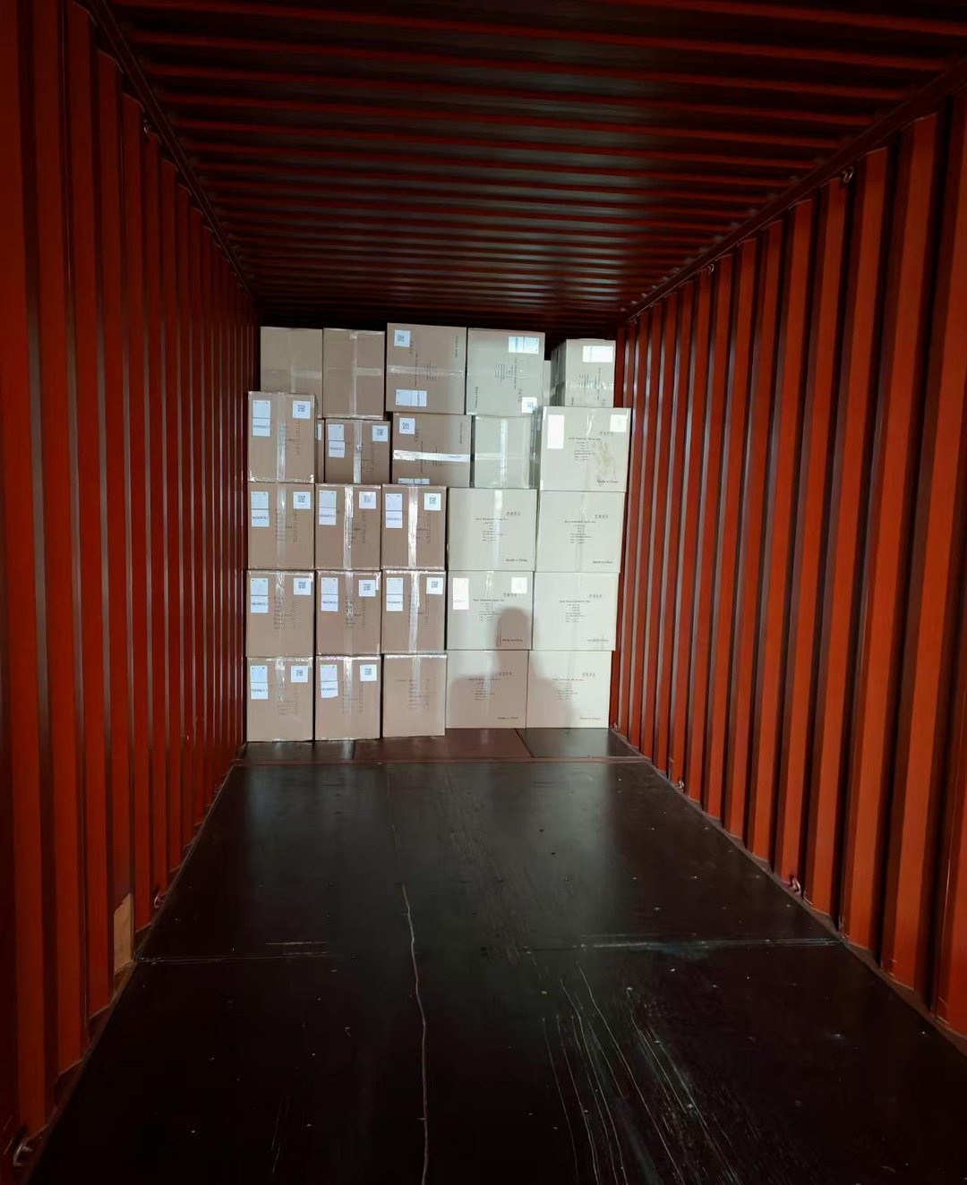 Cardboard cartons of electric fans floor-stacked inside a 40HQ container at Qingdao, September 2026